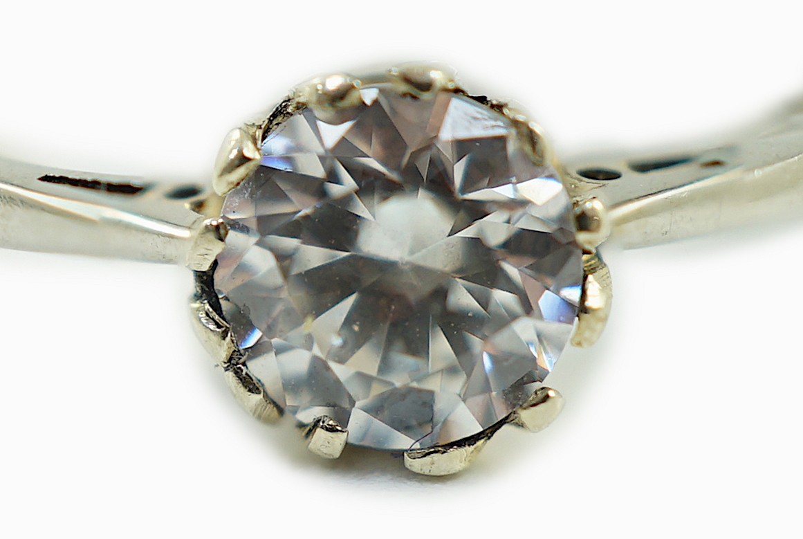 An 18ct and plat set and simulated diamond ring, the stone diameter approx. 4.5mm, size J, gross weight 1.1 grams.